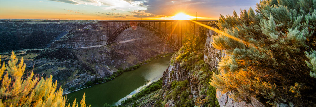 A scenic shot of the sun behind Perrine Memorial Bridge over the Snake River.